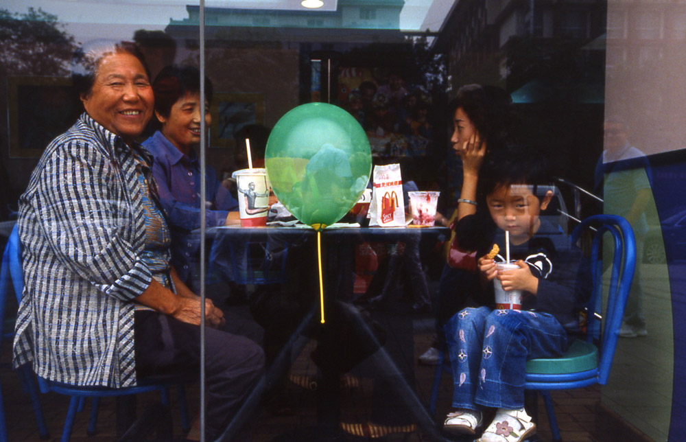 The globalization. A chinese family inside Mc Donald. Xian, China  2005 - © Carlo Sacco