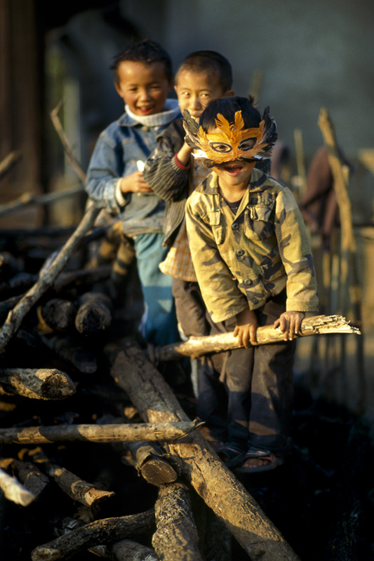 Children playing on piles of wood. Laos 2008 - © Carlo Sacco